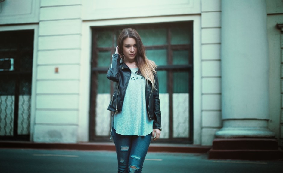 a girl wearing black jacket and blue jeans