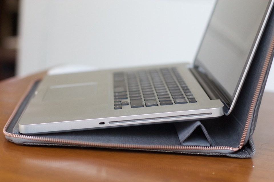 silver laptop with its protection cover bag